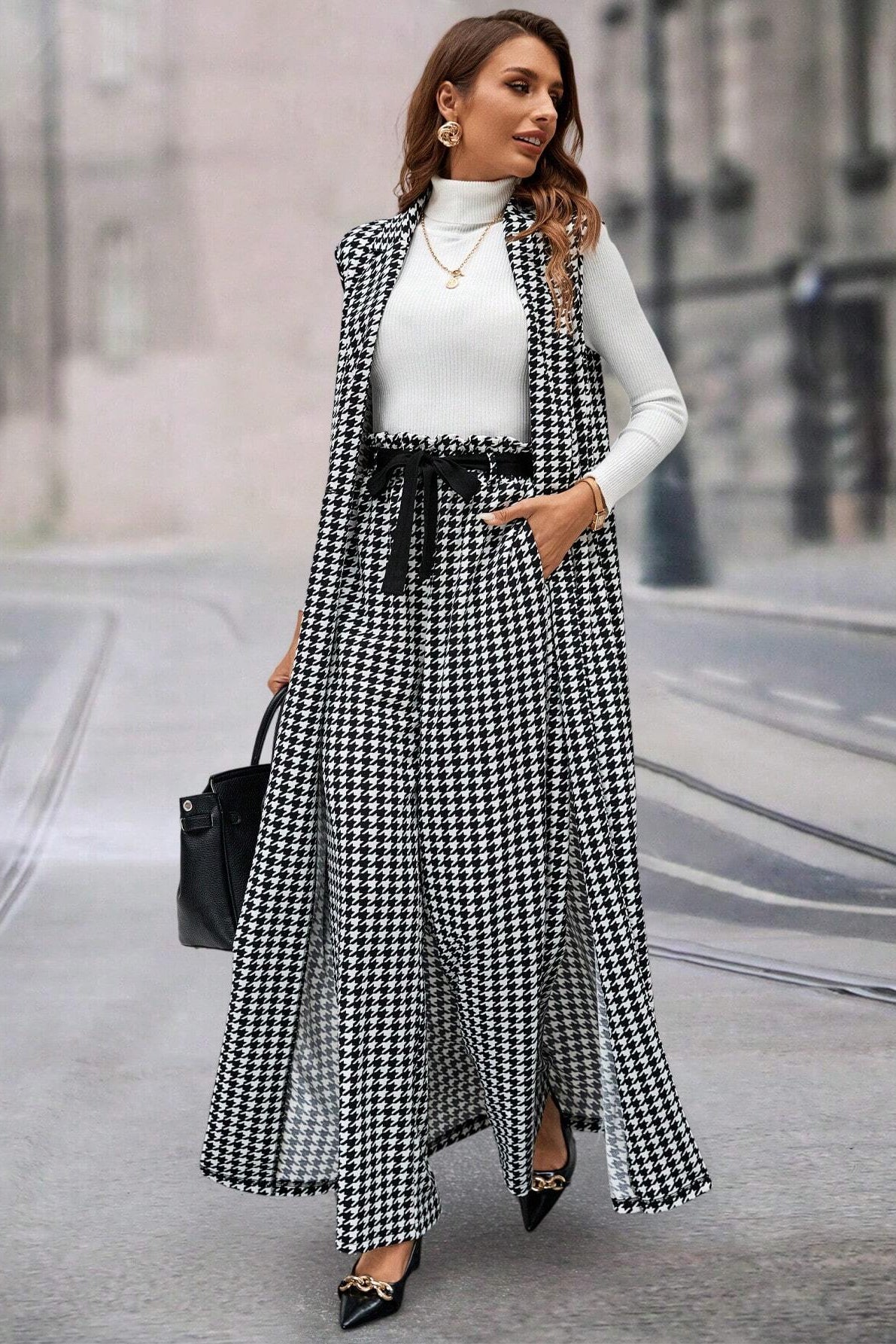 Woman wearing a black and white checkered dress with a white turtleneck and black shoes on a city street.